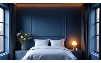 Camera da letto con tonalità blu scuro, letto king-size, finestre con tende oscuranti e illuminazione soffusa per favorire il sonno.